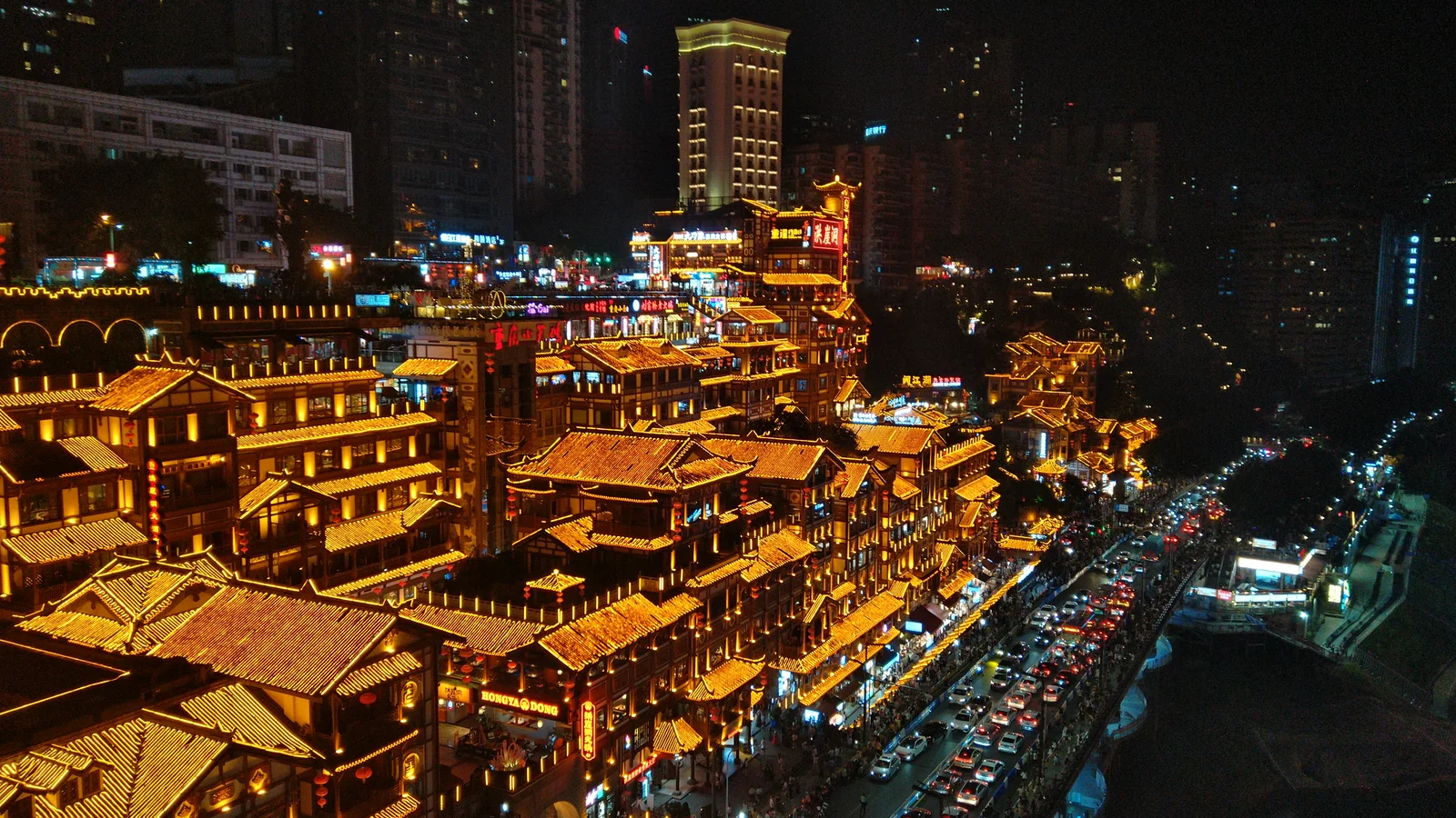 The illuminated terraces of Hongya Cave in Chongqing, seen from Qiansimen Bridge at night.